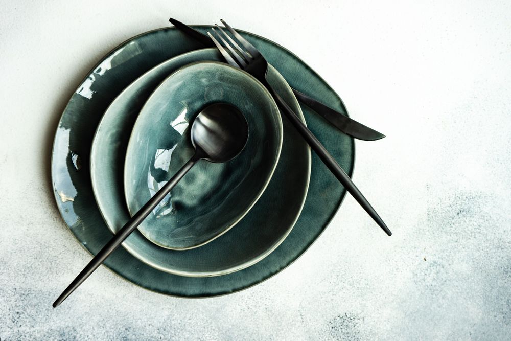 Top view of full table setting with bowls and plates on grey table