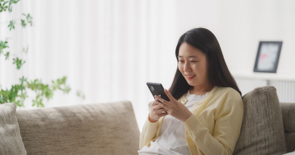 Young South Korean Woman Engaged and Connected Online, Enjoying Leisure Time with Her Smartphone