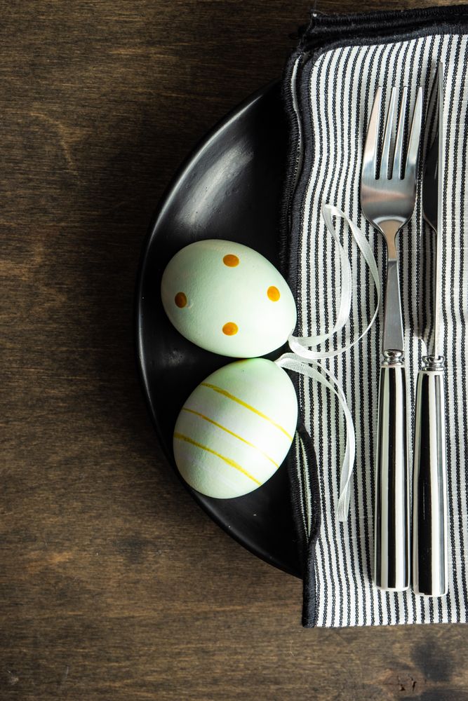 Top view of pastel green eggs on dark plates for Easter dinner