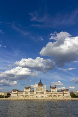 Blue sky and fluffy clouds over Hungarian Parliament building, vertical