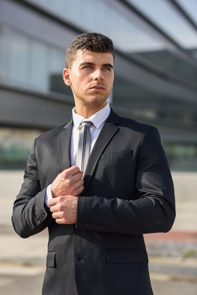 Man looking away adjusting his sleeves