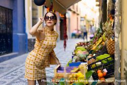 Glamorous woman leaning over fresh fruit in market bYqg3Y