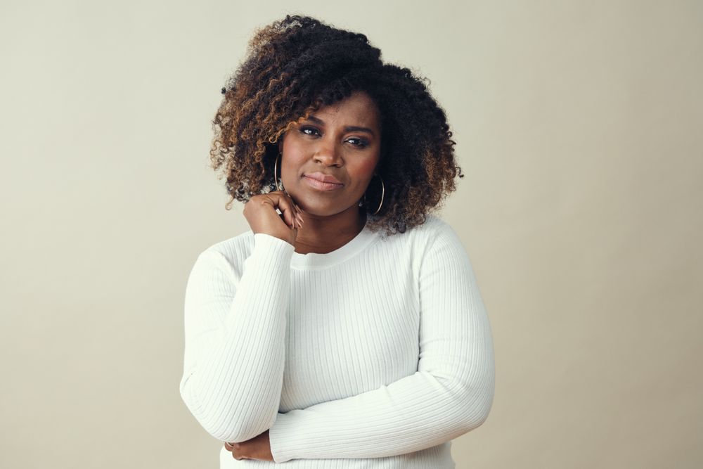 Serious Black woman resting her chin on her hand as she’s thinking carefully