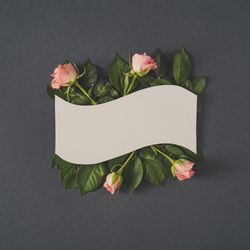 Paper card note with pastel pink rose flowers on dark gray background