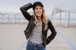 Woman on white wooden pier with ocean on background