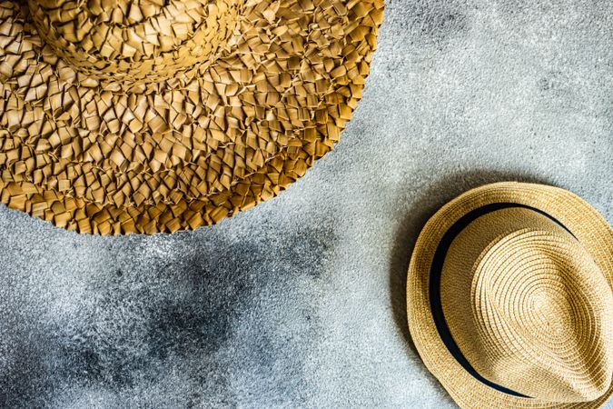 Top view of straw hats on grey counter
