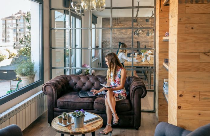 Woman working with laptop sitting on the sofa
