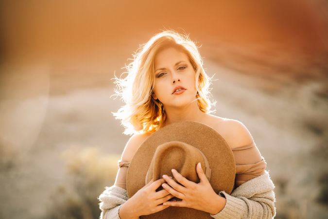 Tender woman holding straw hat on nature