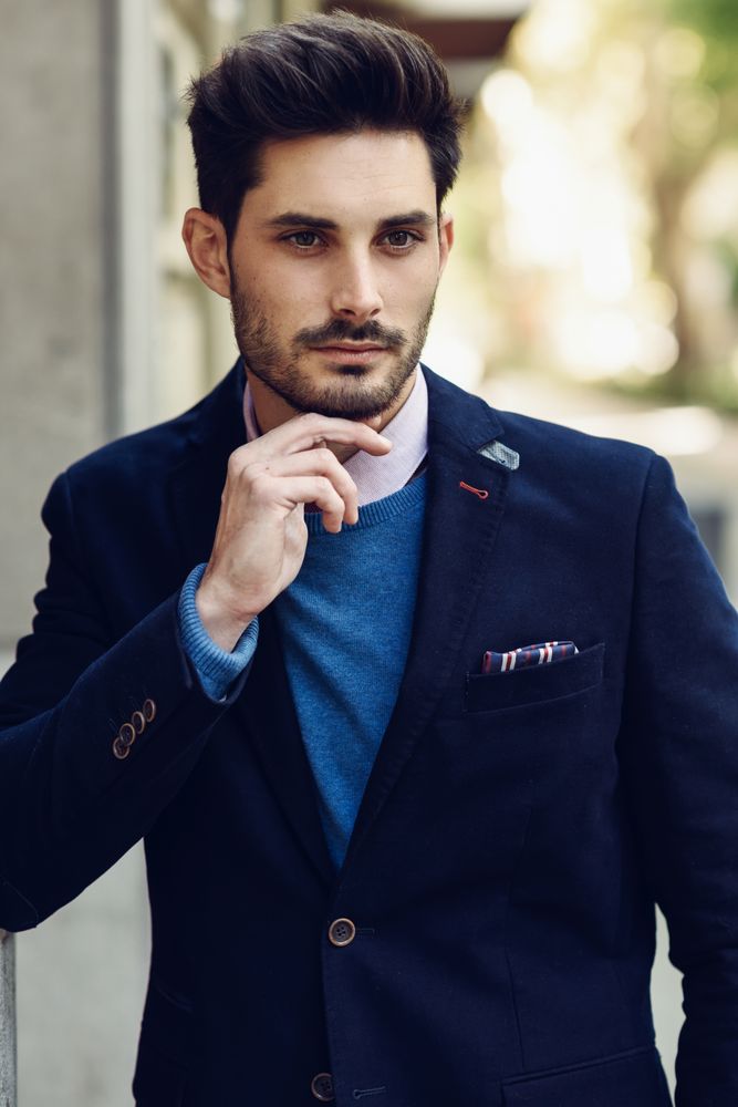 Man in the street wearing elegant suit with hand to chin