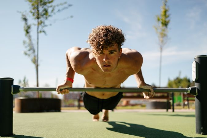 Strong young sportsman doing calisthenics