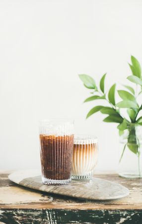 Two cups of ice coffee in glass cups with light background