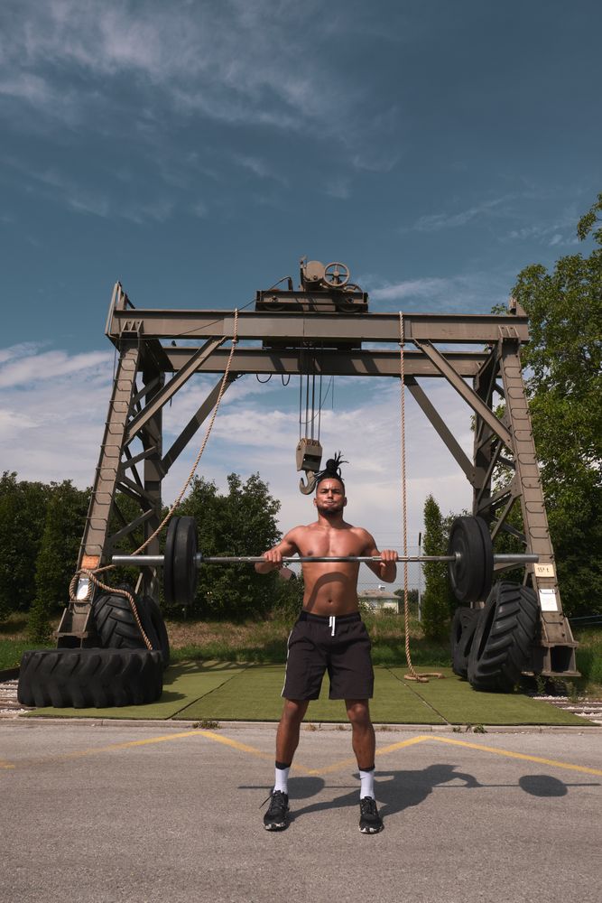 Black guy with barbell in outdoor gym
