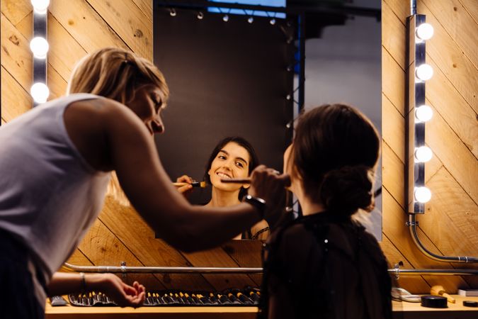 Makeup artist doing makeup for young female artist