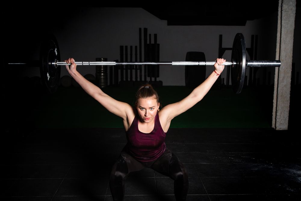 Woman lifting barbell in gym