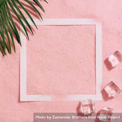 Pink sand with paper square outline and ice cubes and palm leaf begPP5