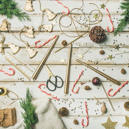 Decorations of stars, candy canes, scissors, candles on light background, square crop