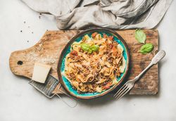 Pasta dinner with minced meat, and cheese on wooden board