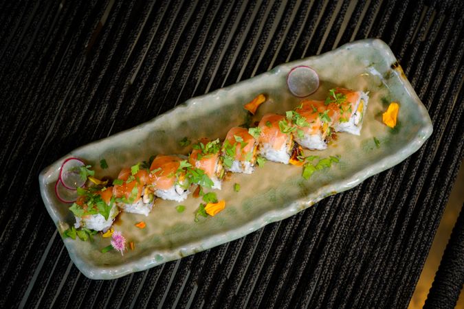 Delicious uramaki sushi with salmon and fresh vegetable with avocado served on marble tray