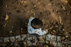 Overhead shot of toddler walking outside on a path