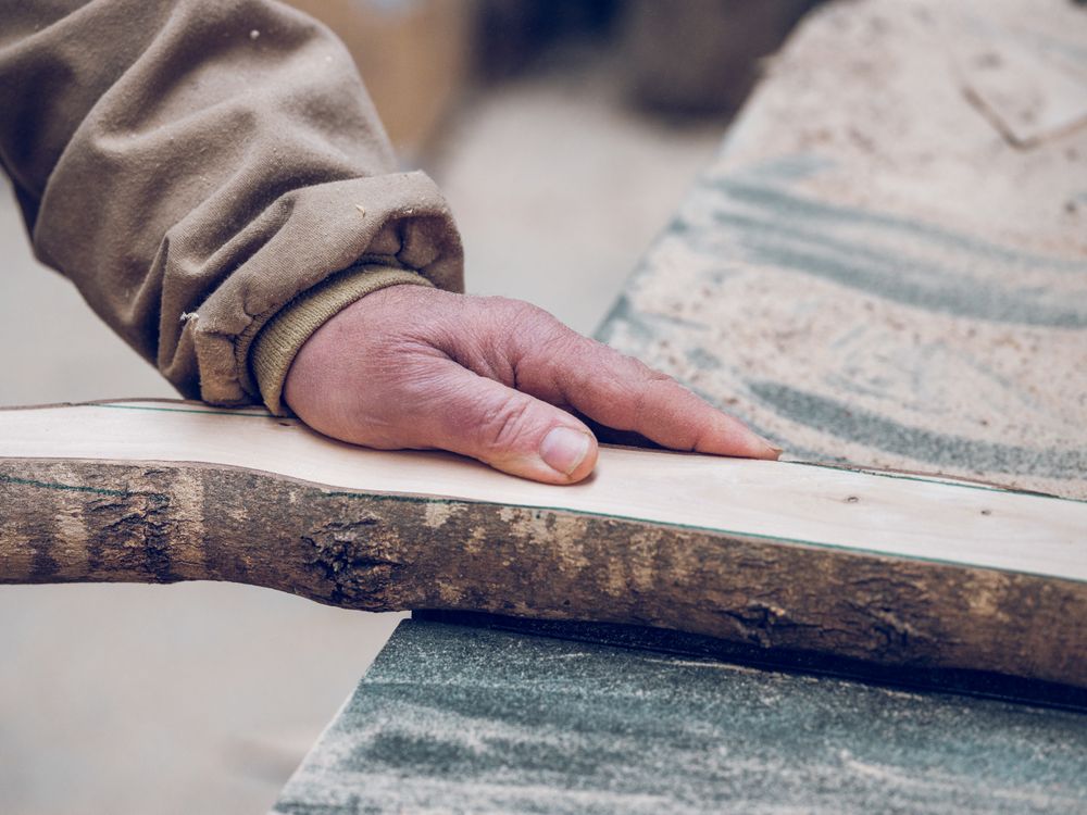 Unrecognizable craftsman with wooden piece