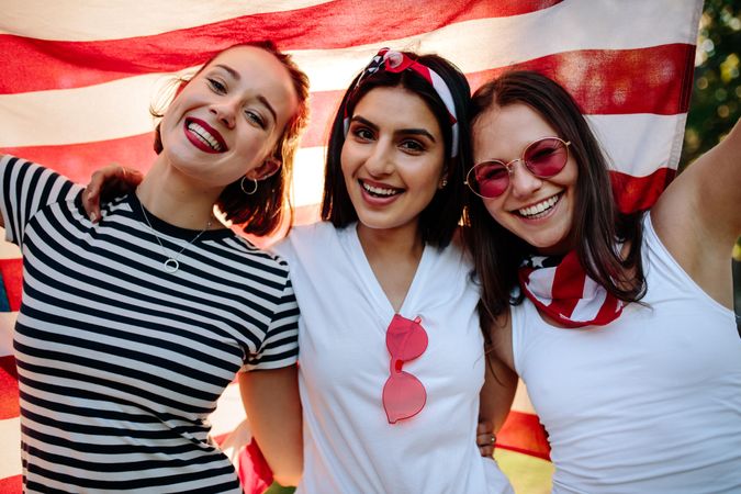 Three female friends smiling with American flag