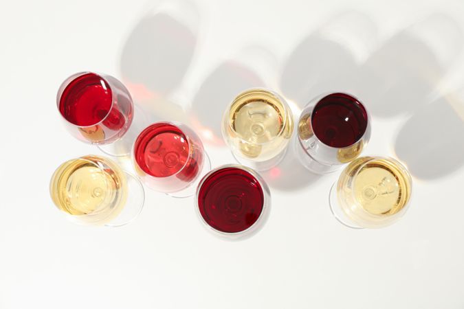 Flat lay composition. Glasses with different wine on blank background, top view
