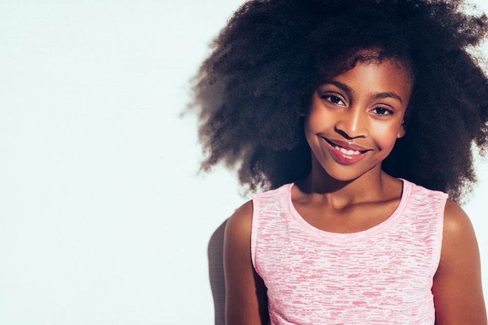 Studio portrait of young girl smiling in pink vest