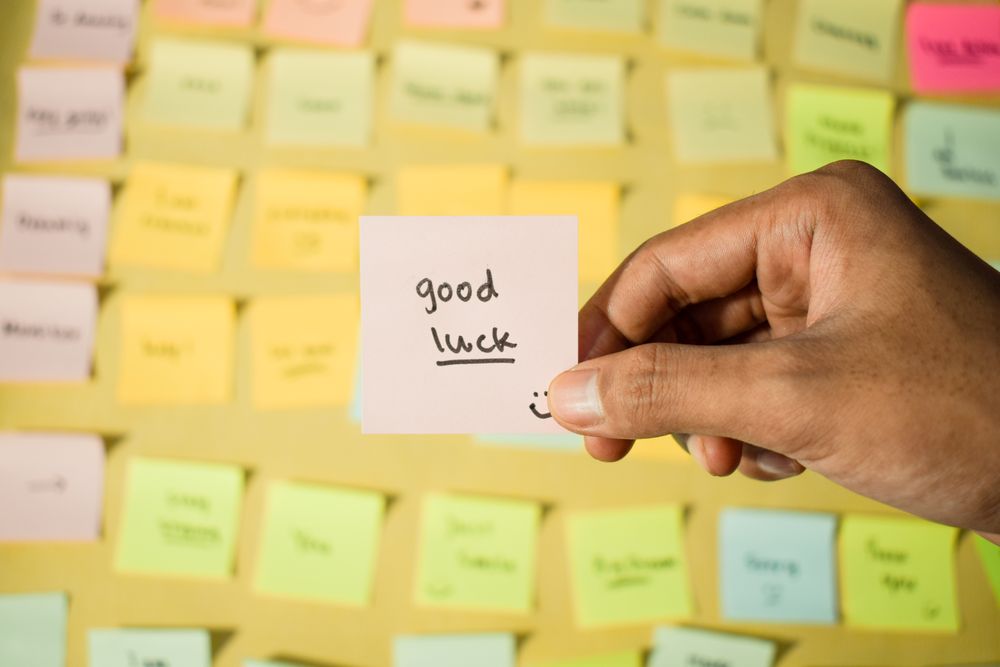 Hand hold sticky notes with words Good Luck