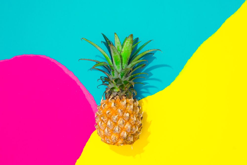 Pineapple on pattern of ripped paper in vivid colors