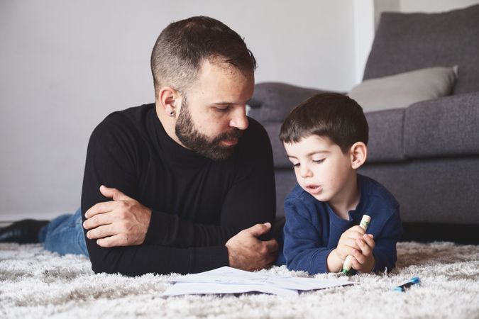 Father and son drawing on floor