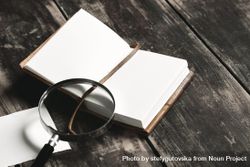 Open notebook and magnifying glass on wooden table 5Q1rn5