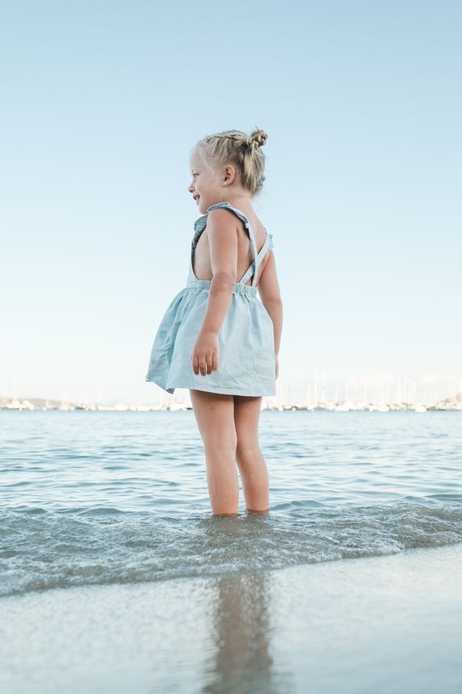 Little girl standing in sea at beach