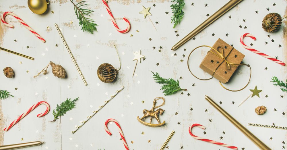 Decorations of stars, candy canes, scissors, candles on light background, wide composition
