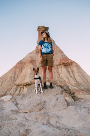 Woman in front of butte on trek with dog