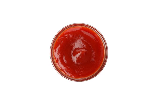 Glass bowl with tomato sauce isolated on neutral background