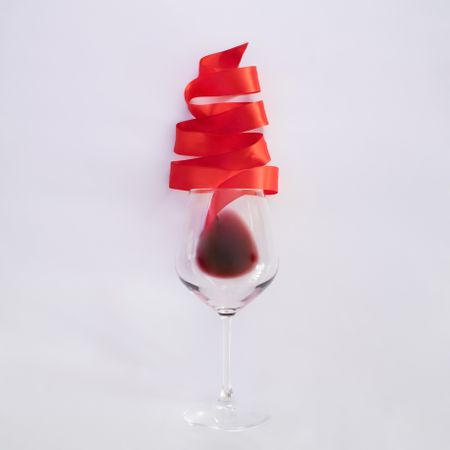 Red Christmas tree ribbon coming out of wine glass