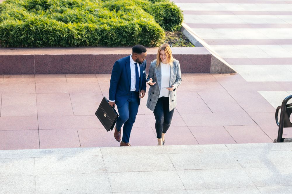 Business colleagues going to the office talking about the company while walking up the stairs