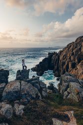 Woman looking at rocks at seaside