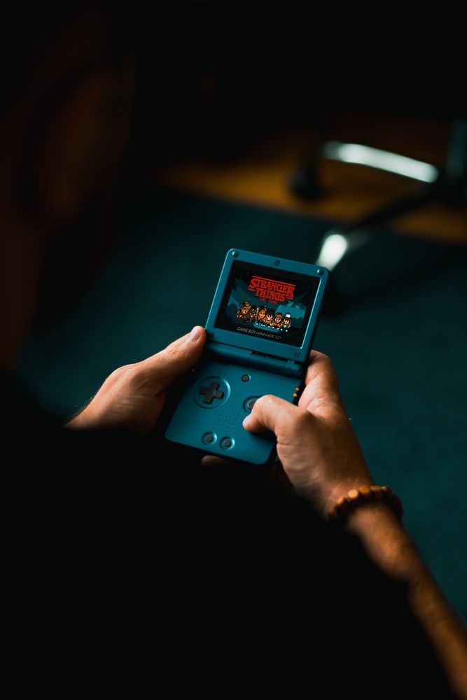 Person holding blue nintendo game boy