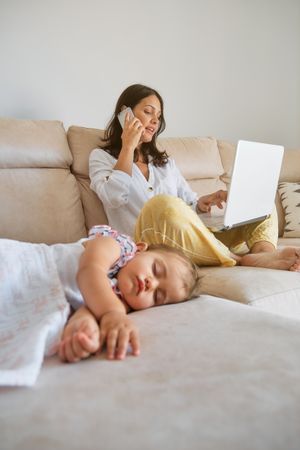 Mother working while daughter sleeping at home