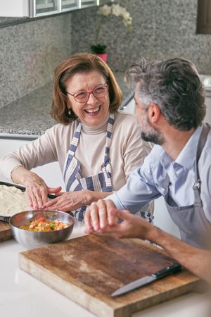 Delighted son with mother cooking at table