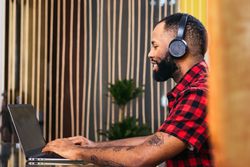 Black man teleworking with laptop from home
