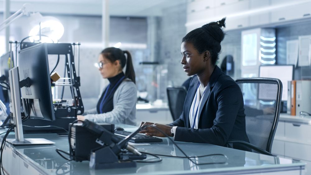 Black Female Scientist Working on a Computer with Her Colleagues at Research Center.