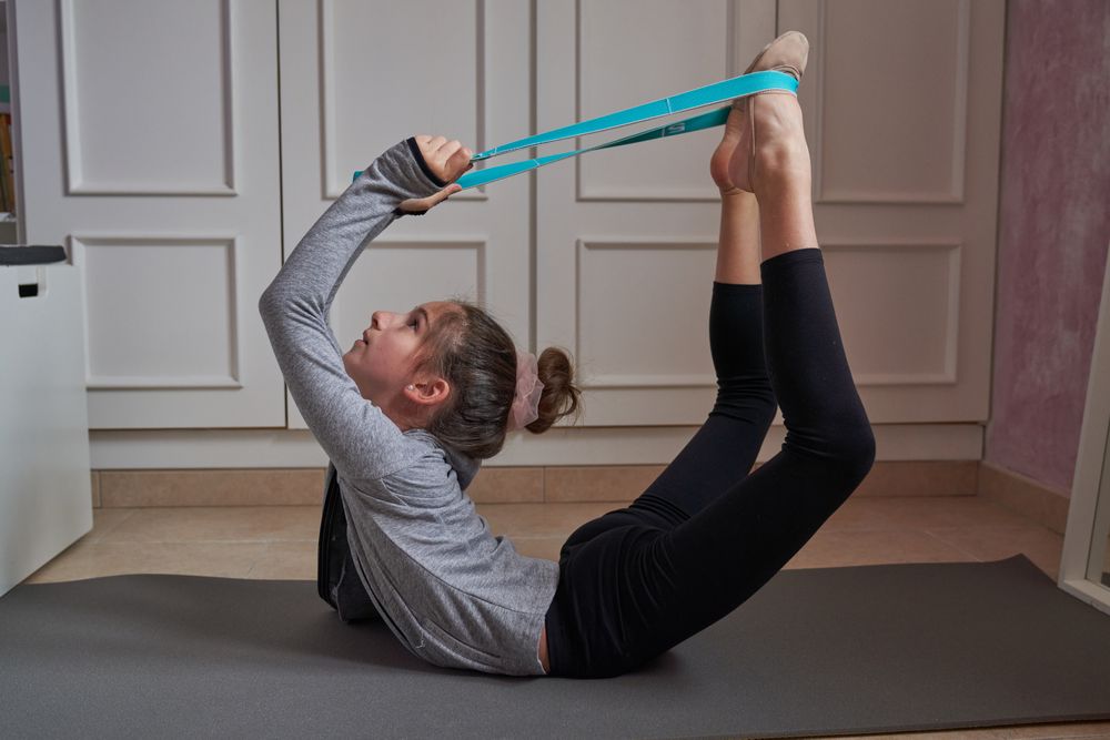 Child exercising with resistance band at home