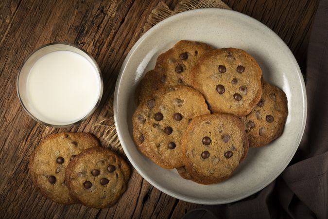 Delicious chocolate cookies with glass of milk on wooden table.