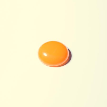 Egg yolk on pastel yellow background