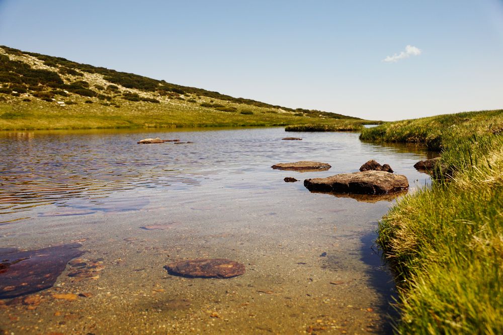 Clear lake at bottom of rocky mountain