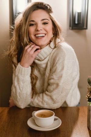 Elegant woman mixing coffee in cafe