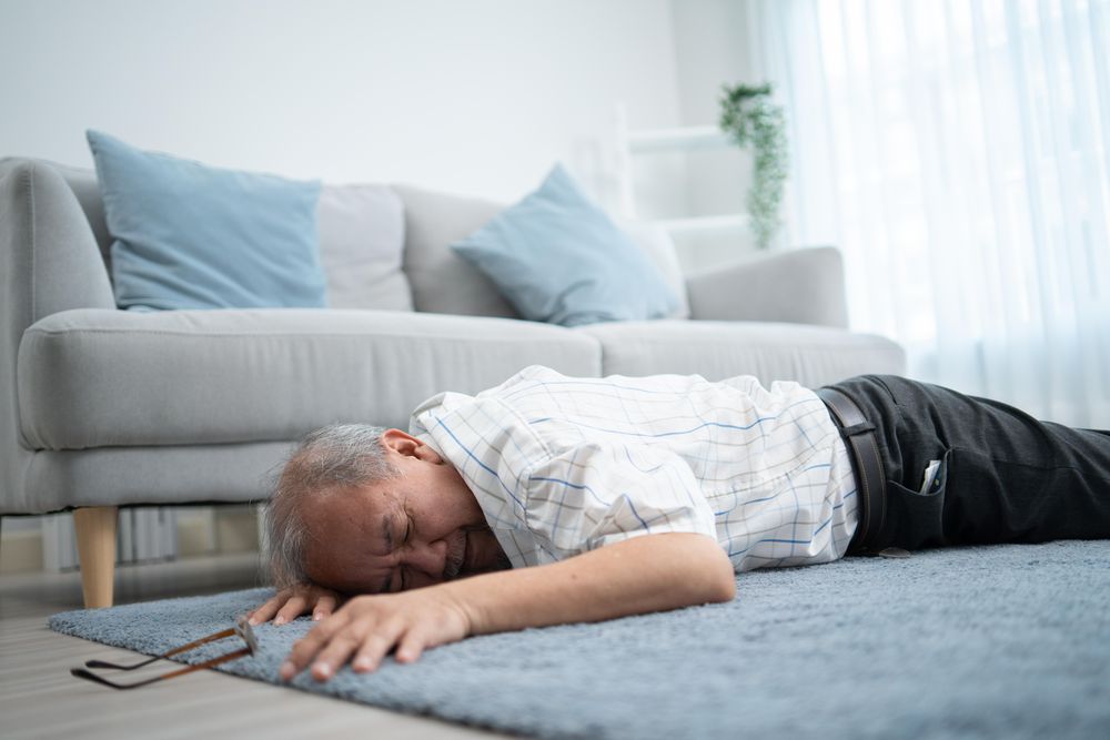 Older male lying stomach down after collapsing at home