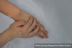 Hands soaking in water 4Ba2DM
